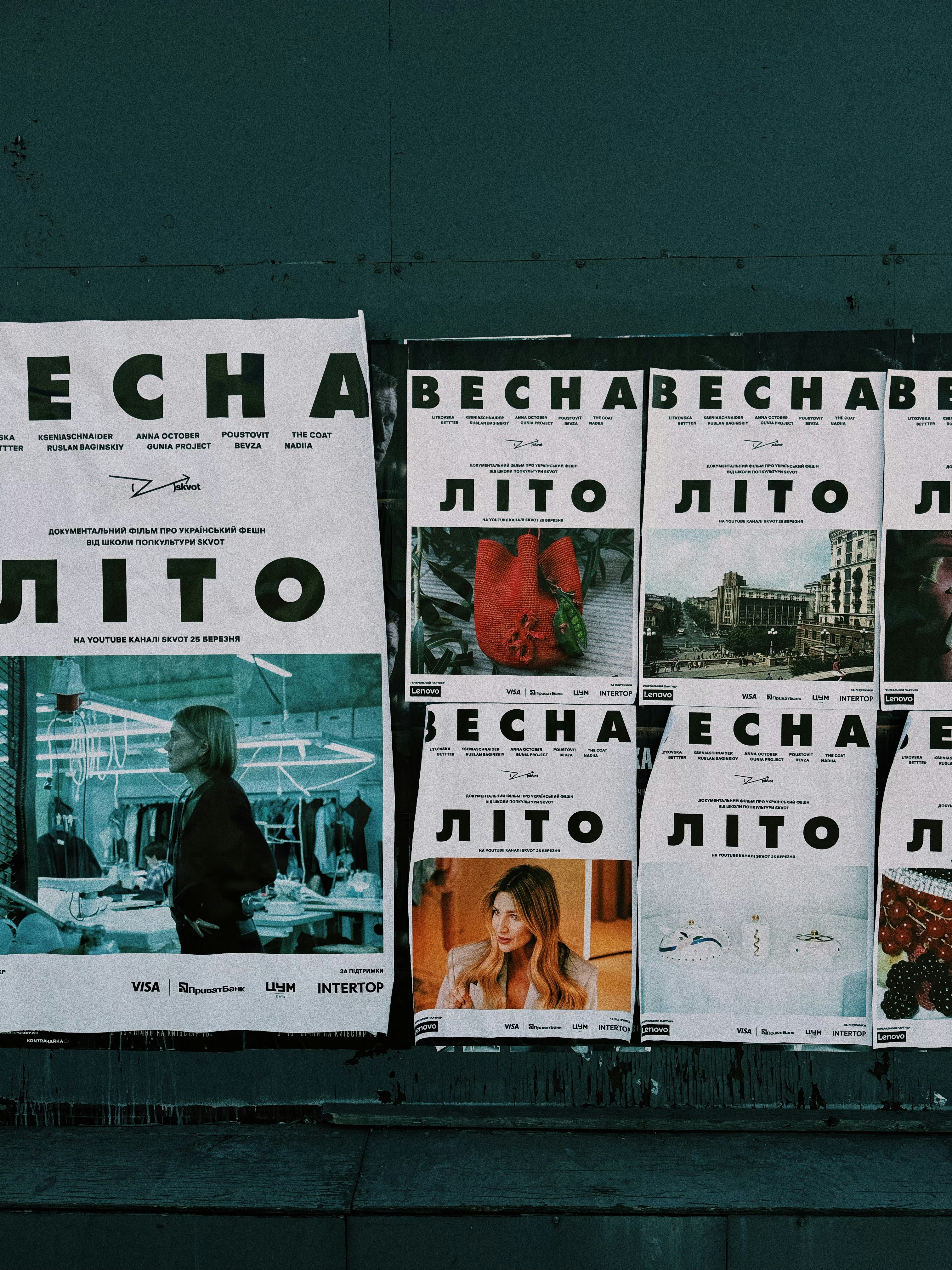 Posters with russian text and images displayed on wall.